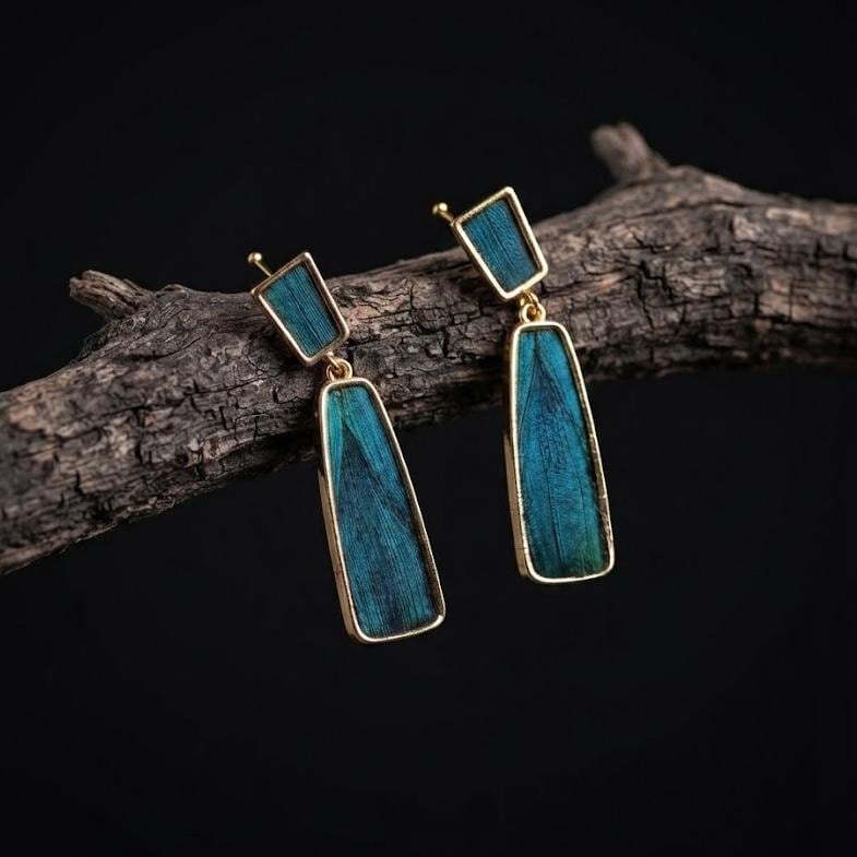 Geometric drop earrings with iridescent blue peacock feather rhombus and tapered panels, gold plated