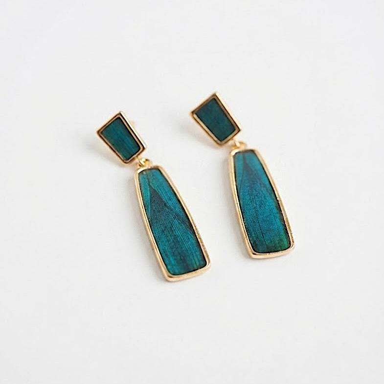 Geometric drop earrings, another angle showing the iridescent blue peacock feather inlay